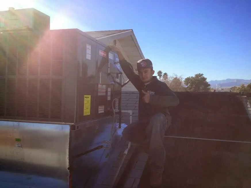 HVAC technician performing HVAC Inspection on a rooftop unit in Holden
